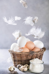 Chicken and quail eggs with feathers flying