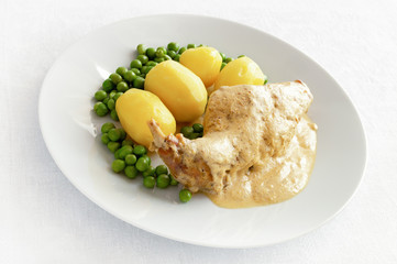 rabbit stewed in mustard, white wine, and sour cream  leg garnished with potato and pea