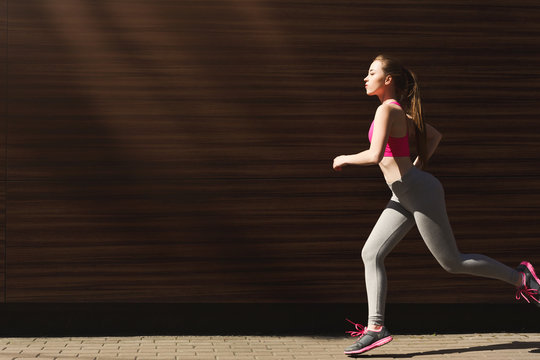 Young woman jogging in city copy space