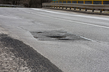 large pit, potholes on the road