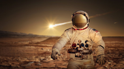 Astronaut exploring the surface of red planet Mars. Space Mission. Elements of this image furnished...