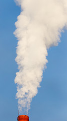 smoke from a pipe in the factory against a blue sky