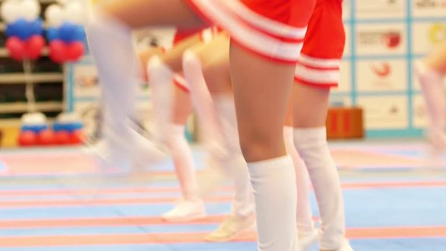 Attractive cheerleaders in red dresses dancing at the karate championship