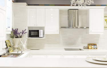 Modern design interior with white glossy kitchen in a luxurious apartment in gray and white tones. Stylish white modern kitchen interior.
