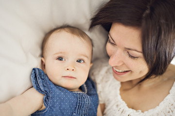 mother playing with her baby in the bedroom