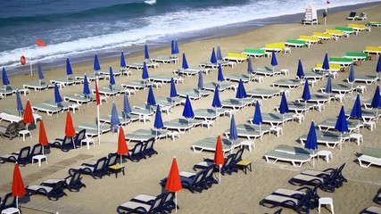 Folded up umbrellas and empty sun loungers in the morning on Alanya Beach in Turkey Country. Antalya is one of the most popular tourist holiday destinations, located on the southern coast of the count - Powered by Adobe