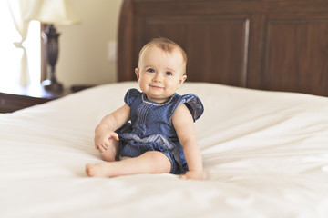 Portrait of a baby on the bed in her room