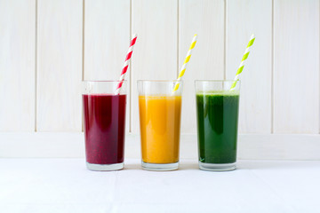 Detox drinks in glass: fresh smoothies from vegetables: beet, pumpkin and spinach on white background