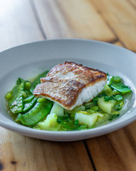 Fish on bed of greens, peas