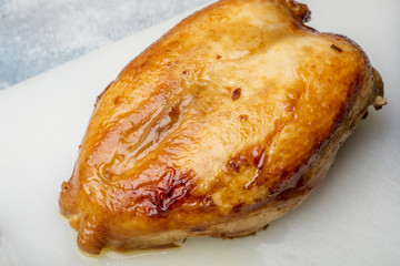 Fried chicken breast on a cutting board. Golden crust