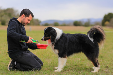 Man with a dog drinking