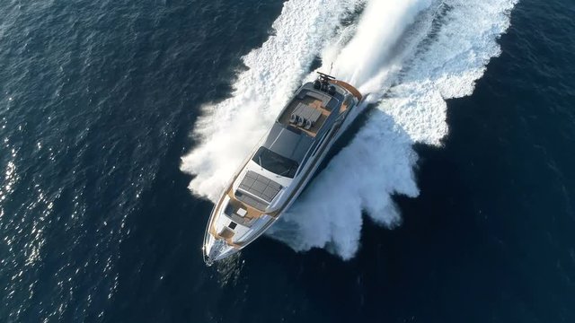 Aerial perpendicular view of a luxury yacht navigating fast.