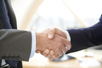 Handshake. Close-up shot of two businessman wearing suit and shaking hands. 