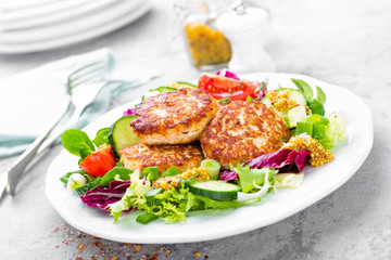 Cutlets and fresh vegetable salad on white plate. Fried meatballs with vegetable salad