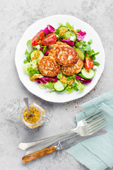 Cutlets and fresh vegetable salad on white plate. Fried meatballs with vegetable salad