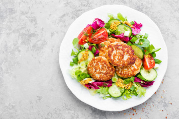 Cutlets and fresh vegetable salad on white plate. Fried meatballs with vegetable salad