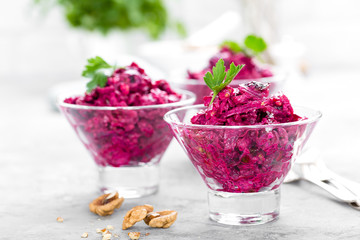 Beet salad. Salad of boiled beet. Beetroot salad with prune, walnuts and sour cream on white background