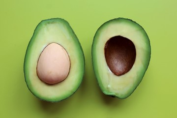 Cut in half avocado on a green background