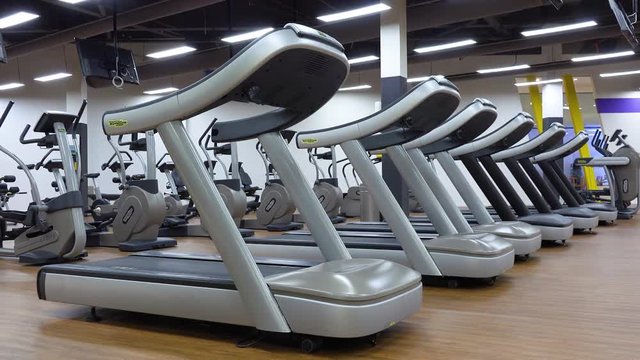 A row of treadmills in an empty gym