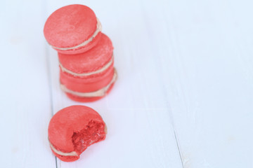 Colorful macaroons and flowers on table