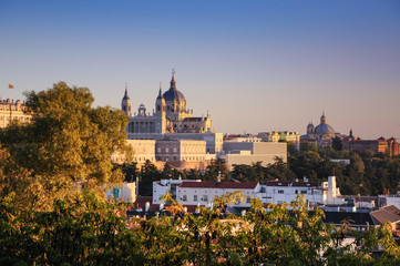 The west wing of Royal Palace of Madrid and Cathedral of Santa María la Real de la Almudena illuminated with sunset view from the north (Debod temple). Madrid, Spain
