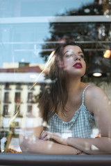 portrait of young woman behind the glass