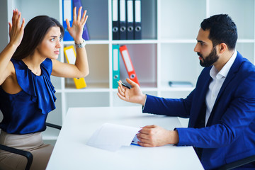 Man and woman staring at each other with hostile expressions.