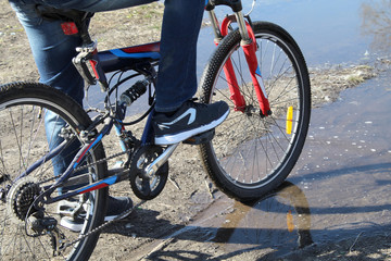 Fototapeta premium teen riding bike on water puddle