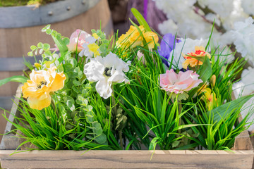 artificial flowers in wooden box outdoors, street decorations close up