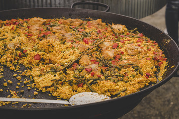 Traditional paella with chicken and vegetables at street food market