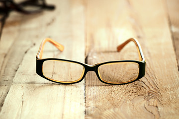Black orange glasses on wooden board