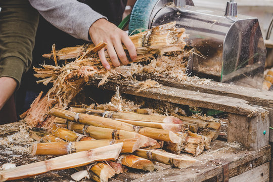 Man Queezing Sugar Cane Juice At Street Food Market