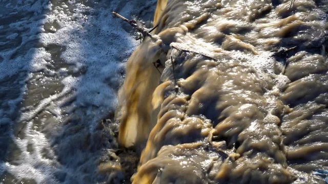 Dirty waste is drained into a stormy river. Close-up, high detail. 4K, 25 fps