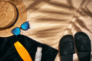 Summer background with straw hat, sunglasses, sunscreen bottle and flip flops