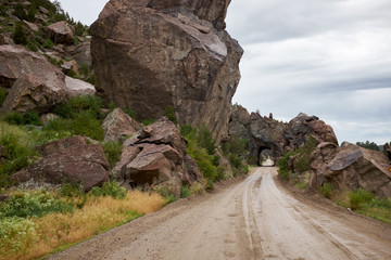 Country road along rocks toward tunnel