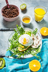 Tasty sandwich with avocado and egg, arugula on concrete background. Delicious breakfast.