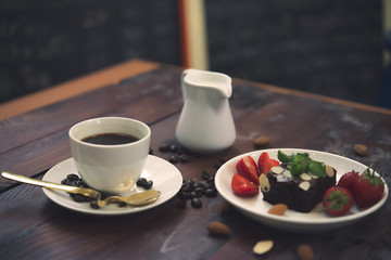 Hot coffee in white cup on wood background,Brownie with Fresh strawberry on white plate