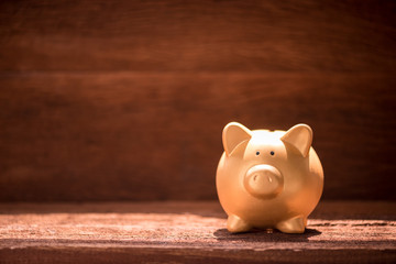 Fototapeta premium gold piggy bank on wooden table