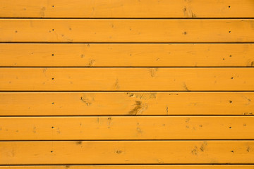 Retro orange painted surface backdrop. Horizontal lines of wooden boards background. Aged cracked wood texture