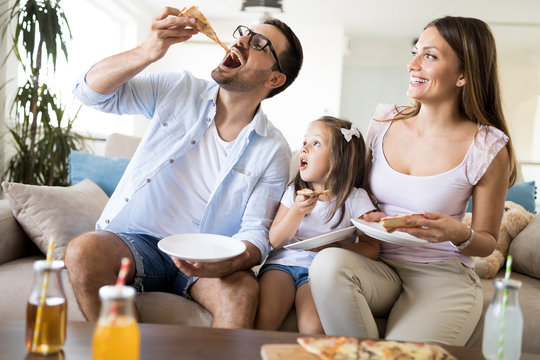 Portrait of happy family sharing pizza at home