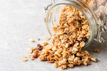 Fresh granola in glass jar on gray stone background
