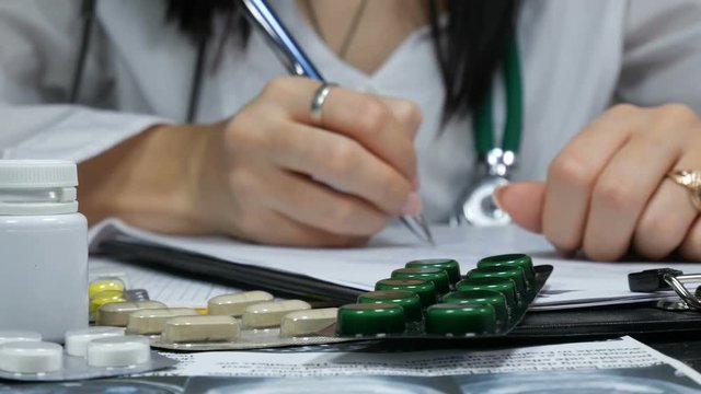 doctor working at the table with different pills