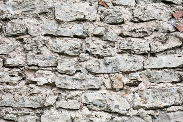 Old wall made of big stones and broken bricks. Vintage rough blocks surface background