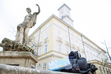 Fototapeta premium travel concept. camera map and backpack with blurred european town on background