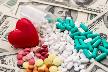 Red heart with colour tablets on dollar banknotes