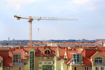 Dźwig, żuraw na pięknym kolorowym osiedlu mieszkaniowym we Wrocławiu. - obrazy, fototapety, plakaty