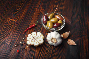 Olives capers garlic pepper on a wooden table