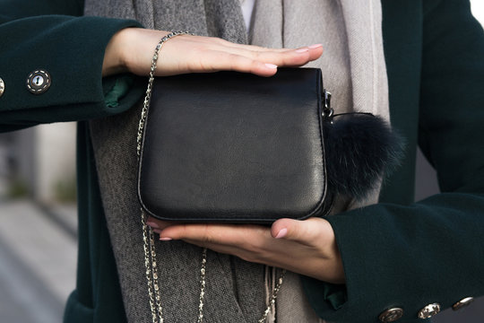 Stylish young woman holding little black purse