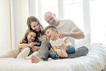 Obraz premium Family with young children to bed in the bedroom
