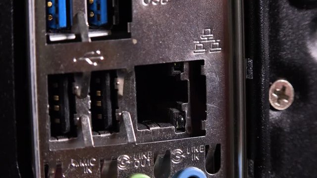 A cable is pulled out of a port on a desktop computer - closeup